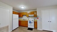 This efficiently designed one-bedroom, one-bathroom unit offers a practical and cohesive layout across a single floor. Wood-look plank flooring runs throughout the entire space, providing a consistent and easy-to-maintain finish that ties each room together.

The kitchen features warm honey-toned cabinetry with ample upper and lower storage, light countertops, and a full suite of appliances including a white refrigerator, electric range with overhead ventilation, and a single-basin sink. The layout maximizes the available counter space and offers straightforward functionality.

The living room is a clean, open area with neutral gray walls, bright white trim, and multiple electrical outlets positioned along the walls, offering flexibility for furniture arrangement. Natural light enters through a large window dressed with horizontal blinds.

The bedroom is a cozy, well-proportioned room featuring a natural light source through a window with blinds, neutral walls, and a full-size double-door closet providing solid storage capacity. The understated design keeps the room versatile and adaptable.

The bathroom continues the wood-look flooring and features a wall-mounted vanity sink, a mirrored medicine cabinet, a toilet, and a shower area, all set against soft gray walls. The space is compact yet fully functional, with built-in towel bars and overhead lighting rounding out the practical amenities.