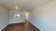 This two-story, 1-bedroom, 1.5-bathroom residence offers a comfortable and efficiently designed layout across its two levels. The main living area features rich, dark hardwood-style flooring, neutral gray walls, and a textured ceiling, creating a clean and understated aesthetic. A distinctive pass-through window connects the living room to the kitchen, allowing light to flow between the two spaces and lending an open, connected feel.

The kitchen is equipped with white cabinetry, granite-style laminate countertops, and a coil-burner electric range, providing functional workspace for meal preparation. Adjacent areas offer additional storage and utility space.

The bedroom is carpeted for comfort and includes a ceiling fan with light fixture, a walk-in closet, and a window that allows natural light to fill the room. The full bathroom features white tile surround with a tub-shower combination and chrome fixtures, maintaining a bright and clean appearance. A half bathroom provides added convenience for guests.

Throughout the residence, neutral tones and consistent finishes create a cohesive, move-in-ready environment. The two-floor configuration offers a sense of separation between living and sleeping areas, making efficient use of the available square footage for comfortable day-to-day living.