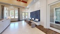 This expansive 4,290 square foot community center at Tapestry Long Farm boasts a thoughtfully designed single-story layout. The space seamlessly blends functionality with aesthetics, featuring a modern architectural style with high ceilings and ample natural light throughout.

Upon entering, visitors are greeted by an elegant reception area with a curved desk and striking chandelier. The center's design incorporates a harmonious color palette of whites, blues, and warm wood tones, creating a welcoming atmosphere. Large windows and glass doors allow for abundant natural light and views of the surrounding landscape.

The facility includes a state-of-the-art fitness center equipped with cardio machines and weight training equipment. Adjacent to this is a game room featuring a billiards table, providing a recreational space for residents. Multiple lounge areas are scattered throughout, offering comfortable seating arrangements for relaxation and socialization.

A notable feature is the spacious multi-purpose room with a sleek kitchenette, ideal for community gatherings and events. The center also includes private meeting spaces and a business center for residents' convenience. Stylish decor elements, such as modern artwork and designer lighting fixtures, enhance the overall ambiance.

The flooring alternates between polished tiles, hardwood, and carpeted areas, depending on the room's function. Large storage units are discreetly integrated into the design, ensuring a clutter-free environment. This meticulously planned community center caters to diverse needs, promoting an active and social lifestyle for its residents.