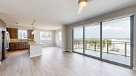 Located in Doral, FL, this well-appointed 3-bedroom, 2-bathroom residence offers a thoughtfully designed single-floor layout with modern finishes throughout. Light wood-tone flooring flows seamlessly across the open-concept living area, which is anchored by a ceiling fan and floor-to-ceiling sliding glass doors that open onto a private balcony — framing expansive views of the surrounding Doral cityscape and greenery beyond.

The kitchen is a standout feature, equipped with rich wood cabinetry, stainless steel appliances, a tile backsplash, granite countertops, and a peninsula with pendant lighting — ideal for both cooking and casual dining. The space connects naturally to the living area, creating an easy flow for everyday living.

The primary bedroom is generously sized, complete with a ceiling fan, neutral walls, and access to a well-organized walk-in closet with built-in shelving and dual hanging rods. The two bathrooms are finished with wood-toned tile flooring, granite vanity countertops, and warm cabinetry. The primary bath includes a full tub and shower with tile surround and grab bar fixtures, while the second bath offers a similarly refined aesthetic. Additional bedrooms are bright and versatile, each featuring light flooring and ample natural light.