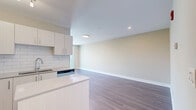 Located on the 18th floor at 196 Dundas St in downtown London, Ontario, this modern one-bedroom, one-bathroom unit offers a well-designed layout with contemporary finishes throughout. The open-concept kitchen and living area serves as the heart of the unit, featuring crisp white cabinetry, a classic white subway tile backsplash, and a central island with a clean quartz countertop — ideal for both meal preparation and casual dining. A full suite of stainless steel appliances, including a French door refrigerator, electric range, built-in microwave, and dishwasher, completes the kitchen. Warm-toned luxury vinyl plank flooring runs throughout the living areas, adding both durability and a cohesive aesthetic. The living room offers a bright, open space with a neutral colour palette that lends itself well to a variety of décor styles. The bedroom is a comfortable size, featuring a double-door closet and the same warm flooring carried throughout the unit. The four-piece bathroom is elegantly appointed with large-format floor tiles, a soaker tub, and striking marble-effect wall surround, paired with a clean vanity and modern fixtures. The overall design is clean, contemporary, and move-in ready.