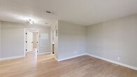 Located at 2065 Dowlen Rd in Beaumont, Texas, this single-story home offers a clean, modern aesthetic throughout its thoughtfully designed layout. Light wood-look flooring runs continuously across the entire space, creating a cohesive and bright atmosphere. Neutral gray walls and crisp white trim complement the contemporary finishes found in every room.

The open-concept living and dining area is welcoming and functional, featuring a front entry door, recessed lighting, and a ceiling fan that enhances airflow and comfort. Large windows allow natural light to fill the space, offering views of the surrounding neighborhood.

The kitchen is efficiently designed with gray shaker-style cabinetry, sleek black hardware, white quartz countertops, a stainless steel undermount sink, and a full-size refrigerator — providing both style and practicality.

The spacious primary bedroom is a standout feature, offering generous room to furnish comfortably. It includes a ceiling fan with lighting, a window with natural light, and two dedicated closets for ample storage. The bathroom features a tub-shower combination with a clean white surround and matte black fixtures. A dedicated laundry area and two closets round out the home's practical offerings.