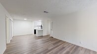 This 910-square-foot, single-story apartment at 1600 Nesbitt Lane in Nashville, TN offers 2 bedrooms and 2 bathrooms with a clean, modern aesthetic throughout. Wood-look luxury vinyl flooring runs through the entire unit, complemented by crisp white walls and textured ceilings. The open living room is a standout, featuring a wood-burning fireplace, multiple windows for natural light, and direct access to an outdoor area via a glass-paneled door. The galley-style kitchen is well-appointed with white shaker cabinets, marble-look countertops, a white subway tile backsplash, black appliances, and a skylight that brightens the space. Both bedrooms are generously sized, each equipped with a ceiling fan and large windows offering outdoor views. The primary bedroom measures 220 square feet and includes access to a dedicated walk-in closet outfitted with wire shelving. Both bathrooms feature a full tub-shower combo with built-in shelving, a white vanity with marble-look countertops, brushed nickel hardware, and wood-look flooring. The unit's consistent finishes and neutral palette create a cohesive, move-in-ready living environment.