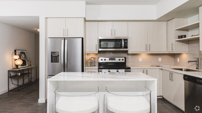 Kitchens with custom cabinetry, bar seating, and built-in shelves - Modera Edgewater