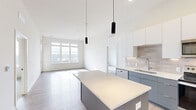 Located at 8680 State Line Rd in Leawood, KS, this thoughtfully designed 3-bedroom, 3-bathroom residence offers a clean, contemporary aesthetic throughout its single-floor layout. The open-concept kitchen and living area serves as the heart of the home, showcasing soaring ceilings, light wood-style flooring, and a large central island with a white quartz countertop and sleek gray cabinetry. The kitchen is equipped with stainless steel appliances, including a range, microwave, refrigerator, and dishwasher, complemented by white upper cabinets, a neutral tile backsplash, and modern pendant lighting. The living area extends naturally from the kitchen, bathed in natural light from expansive windows. Each of the three bedrooms features plush carpeting and generous windows that frame outdoor views of the surrounding Leawood landscape. The primary bedroom, a comfortable retreat, is served by an en suite bathroom featuring a gray vanity with white countertop, wood-style flooring, and a tiled tub-shower combination. Additional bathrooms mirror the same modern finishes. A dedicated hallway and closet round out the functional layout, delivering a cohesive, move-in-ready residence with refined, contemporary finishes throughout.