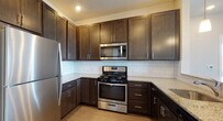 This single-floor residence at 326 NJ-31 in Flemington, NJ offers a well-designed layout with a thoughtful combination of materials and finishes. The open-concept living and dining area features durable wood-look flooring and neutral wall tones, creating a versatile, light-filled space. The kitchen is outfitted with dark espresso cabinetry, granite-look countertops, a subway tile backsplash, and a full suite of stainless steel appliances, including a gas range, microwave, and refrigerator.

The bedrooms are carpeted for comfort, with neutral tones and generous natural light provided by large windows fitted with blinds that frame outdoor greenery. The primary bedroom includes access to a walk-in closet and an en-suite bathroom featuring a glass-enclosed subway tile shower. Additional bedrooms offer standard closets with built-in shelving. A second full bathroom includes a dark-cabinet vanity with a white countertop, a lighted mirror, tile flooring, and a tub/shower combination with subway tile surround. The overall aesthetic is clean and contemporary, providing a functional and comfortable living environment.