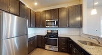 This single-floor residence at 326 NJ-31 in Flemington, NJ offers a well-designed layout with a thoughtful combination of materials and finishes. The open-concept living and dining area features durable wood-look flooring and neutral wall tones, creating a versatile, light-filled space. The kitchen is outfitted with dark espresso cabinetry, granite-look countertops, a subway tile backsplash, and a full suite of stainless steel appliances, including a gas range, microwave, and refrigerator.

The bedrooms are carpeted for comfort, with neutral tones and generous natural light provided by large windows fitted with blinds that frame outdoor greenery. The primary bedroom includes access to a walk-in closet and an en-suite bathroom featuring a glass-enclosed subway tile shower. Additional bedrooms offer standard closets with built-in shelving. A second full bathroom includes a dark-cabinet vanity with a white countertop, a lighted mirror, tile flooring, and a tub/shower combination with subway tile surround. The overall aesthetic is clean and contemporary, providing a functional and comfortable living environment.