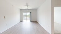 Located at 5945 Arlo Dr in Indianapolis, IN, this well-appointed 2-bedroom, 2-bathroom single-story home offers a clean, modern aesthetic throughout. The open-concept kitchen is a standout feature, boasting white cabinetry, a large center island with a quartz countertop and integrated sink, stainless steel appliances including a range, microwave, and refrigerator, and recessed lighting above light wood-style flooring. The spacious living room extends naturally from the kitchen and features a ceiling fan, light wood-style floors, and a sliding glass door that opens to an outdoor balcony, filling the space with natural light and outdoor views. Both bedrooms are carpeted and bright, each with large windows overlooking greenery. The generously sized primary bedroom includes a ceiling fan and access to a well-organized walk-in closet with built-in shelving and hanging rods. The primary bathroom features a wide dual-sink vanity with white cabinetry and quartz countertops, a large mirror, and a glass-enclosed tiled shower. The second closet offers wire shelving for additional storage. Neutral tones, white walls, and consistent modern finishes create a cohesive and inviting atmosphere throughout the entire home.