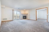 Located at 8550 Greenway Blvd in Middleton, WI, this one-bedroom, one-bathroom unit offers a well-designed, single-floor layout with generous living space. The open-concept living and dining area flows seamlessly into the kitchen, creating an inviting, connected feel throughout. The living room is anchored by a tile-surround gas fireplace and features plush carpeting and a sliding glass door that opens to a private balcony with natural views — an ideal spot to enjoy the outdoors. The kitchen is equipped with light wood cabinetry, white appliances, a peninsula with a built-in sink, and hardwood-style flooring. A pantry closet just off the kitchen provides additional storage convenience. The spacious bedroom offers a large window with natural light, carpeted flooring, and access to a generous walk-in closet with full rod and shelf systems. The full bathroom includes a wide vanity with a single sink, an overhead mirror, and a tub-shower combination. A dedicated in-unit laundry room houses a full-size washer and dryer with built-in shelving. Three closets throughout the unit ensure plentiful storage, and a hallway connects all areas efficiently. The textured ceilings and warm wood trim details lend a consistent, cohesive aesthetic throughout the home.