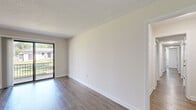 This single-floor, 3-bedroom, 2-bathroom home offers a clean and modern living environment with a thoughtful layout. Throughout the space, durable wood-look flooring and crisp white walls create a bright, cohesive aesthetic complemented by textured ceilings.

The living room is a comfortable and open space anchored by a sliding glass door that leads to a private balcony, inviting natural light and outdoor views. The galley-style kitchen is well-equipped with stainless steel appliances including a gas range, microwave, refrigerator, and dishwasher. Grey shaker-style cabinetry and granite-look countertops provide ample storage and workspace, while a skylight enhances the sense of brightness.

The primary bedroom is generously sized and connects to the layout via hallways that also serve two additional bedrooms, each featuring windows that bring in natural light. Two dedicated closets provide convenient storage throughout.

Both bathrooms are finished with granite-topped vanities and grey cabinetry consistent with the kitchen's design. One bathroom features a full tub-shower combination with floor-to-ceiling stone-look tile surround, adding a refined touch. The home's neutral palette and updated finishes make it a move-in ready space suitable for a variety of lifestyles.