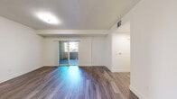 Located at 200 E Tenth St in Gilroy, California, this well-appointed single-floor unit offers a clean, modern aesthetic throughout. The open living area is a standout feature, showcasing rich wood-look flooring that extends seamlessly through much of the space. Large sliding glass doors flood the room with natural light and provide direct access to an outdoor balcony or patio, creating an inviting indoor-outdoor connection. The kitchen is thoughtfully designed with dark espresso cabinetry, granite-style countertops, and black appliances including a range and refrigerator, all set against the same durable wood-look flooring. A dedicated bedroom offers plush carpeting underfoot and generous built-in closet space with double doors, providing ample storage. The full bathroom features a tub-shower combination, a dark vanity with a granite-style countertop, a large mirror, and matching wood-look flooring that ties the design together. An additional versatile room with wood-look flooring offers flexibility for various uses. Throughout the unit, crisp white walls, flush-mount lighting, and consistent finishes create a cohesive, contemporary feel that is both functional and visually appealing.