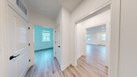 Located at 15 High St in Norwell, MA, this well-designed two-story home offers three bedrooms and three bathrooms across two thoughtfully laid-out floors. The main level is the larger of the two, featuring an open-concept kitchen and living area with light hardwood-style flooring, recessed lighting, and abundant natural light from multiple windows. The contemporary kitchen is a standout, boasting rich dark wood cabinetry, stainless steel appliances, a large center island with a white countertop, pendant lighting, and sliding glass doors that open to an outdoor area. A stylish sputnik chandelier adds a modern touch to the dining space. The bathrooms feature warm wood vanities with white countertops and clean tile flooring, maintaining a consistent modern aesthetic. Connecting hallways are bright and open, with crisp white walls and durable wood-look flooring. The upper level houses the bedrooms, including a generously sized primary bedroom. Bedrooms are finished with neutral carpet, soft natural light from double-pane windows, and clean white walls. Throughout the home, black hardware accents, white trim, and a neutral color palette create a cohesive, modern feel that is both functional and inviting.