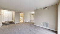 Located at 9965 Good Luck Rd in Lanham, MD, this 2-bedroom, 2-bathroom single-floor residence offers a practical and comfortable layout across a well-utilized footprint. The expansive living room is finished with plush wall-to-wall carpeting and neutral-toned walls, creating a bright, open atmosphere. Large sliding glass doors allow abundant natural light to fill the space and provide views of the outdoors. The kitchen features light wood cabinetry, granite-style countertops, tile flooring, and white appliances including a gas range and refrigerator. The generously sized primary bedroom includes a walk-in closet outfitted with wire shelving for ample storage, as well as a window that brings in natural light. The second bedroom is equally well-proportioned, also with carpeting and a window. Both bathrooms are finished with wood-toned vanities, white countertops, and wood-look flooring. A dedicated laundry area adds everyday convenience. The residence also includes a separate entrance and additional closet space. Throughout, the clean white trim and consistent neutral palette create a cohesive, move-in-ready environment suitable for a variety of lifestyles.