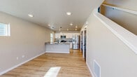 Located at 9600 Liam Loop Unit A in Missoula, Montana, this modern two-story home offers 3 bedrooms and 4 bathrooms across two well-appointed floors. The main level features a bright, open-concept living and kitchen area with light hardwood-style flooring, recessed lighting, and a contemporary front door with frosted glass panels that invite natural light. The kitchen is a standout, showcasing granite countertops, white shaker cabinetry with matte black hardware, stainless steel appliances, a kitchen island with pendant lighting, and a black undermount sink. A convenient half bathroom on the main floor features matching granite counters and marble-look tile flooring. The attached garage provides additional utility with an automatic opener and clean drywall finish. Upstairs, three bedrooms offer light-filled, comfortable spaces with the same durable hardwood-style flooring. The primary bedroom includes a closet with bold navy double doors, adding a distinctive design touch. The upper-level bathrooms are well-finished, featuring white walk-in showers with built-in shelving, marble-look tile flooring, and oil-rubbed bronze fixtures. Neutral tones and clean lines throughout give this home a cohesive, move-in-ready appeal.