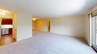 Located at 24 Heritage Cir, Unit 8 in Madison, WI, this 2-bedroom, 1-bathroom single-floor unit offers a well-organized layout across a comfortable footprint. The living room is generously sized, featuring soft wall-to-wall carpeting, neutral cream-toned walls, and sliding glass doors that open onto a private balcony overlooking a lush, tree-lined courtyard—bringing in abundant natural light and peaceful outdoor views. The kitchen is equipped with warm oak cabinetry with brass hardware, white countertops, hardwood-style flooring, and a full suite of stainless steel appliances including a refrigerator, range, over-the-range microwave, and dishwasher. The primary bedroom is notably spacious, bathed in natural light from large windows with views of surrounding greenery, and includes two closets for ample storage. The second bedroom is also carpeted and well-lit with windows overlooking the building exterior. The bathroom features a clean, classic design with white subway tile surrounding a full tub-shower combination and chrome fixtures. A connecting hallway ties the layout together efficiently. The balcony provides a serene outdoor retreat with views of mature trees and well-maintained grounds.