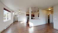 Located at 16511 East Sprague Avenue in Spokane Valley, Washington, this single-floor unit offers a well-designed, open-concept layout filled with natural light. Rich hardwood-style flooring runs throughout the main living areas, complementing the neutral-toned walls and creating a warm, cohesive atmosphere.

The kitchen is a standout feature, equipped with dark espresso cabinetry, stainless steel appliances including a refrigerator, range, microwave, and dishwasher, and a peninsula with pendant lighting overhead. The kitchen flows seamlessly into the spacious living area, which is bathed in natural light from large windows and a glass-panel entry door that also provides outdoor access.

The bedrooms are carpeted for comfort, each featuring windows that bring in ample daylight and baseboard heating for year-round climate control. The bathrooms are clean and functional, each offering a full tub-shower combo with built-in shelving, wood-style flooring, and dark-toned vanity cabinetry. A second, more compact bathroom provides additional convenience.

The floor plan also includes a dedicated hallway with closet space, adding practical storage. The overall design balances modern finishes with functional living, making this a comfortable and well-appointed space in Spokane Valley.