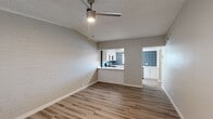 Located at 4301 North 24th Street in Phoenix, AZ, this single-story, one-bedroom unit offers a thoughtfully arranged layout across a compact but well-utilized floor plan. Warm wood-look flooring flows consistently throughout, tying all areas of the space together cohesively.

The living room is bright and welcoming, featuring a ceiling fan with integrated lighting, a textured ceiling, and a painted brick accent wall that adds architectural character. Natural light enters through a large window with blinds, while a glass-paneled entry door further brightens the space.

A pass-through opening connects the living room to the kitchen, creating an open, airy feel between the two areas. The kitchen is a standout feature, showcasing crisp white cabinetry, sleek quartz countertops, and a striking blue patterned tile backsplash that extends to the ceiling. Stainless steel appliances — including a range, microwave, and dishwasher — add a modern, functional touch. A window above the sink allows natural light to fill the space.

The bedroom is a comfortable size, offering a ceiling fan, a painted brick accent wall, a window for natural light, and a wide sliding double-door closet for ample storage. A connecting hallway leads between the main living areas, completing the efficient and well-designed floor plan.