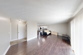 Located at 3945 Hunsaker Dr in East Lansing, Michigan, this single-floor, 3-bedroom, 3-bathroom home offers a well-organized layout with a comfortable, functional design. The open-concept living and dining area is anchored by rich, dark hardwood flooring and neutral gray walls, creating a clean and cohesive aesthetic. A large sliding glass door floods the space with natural light and provides views of the surrounding greenery. The kitchen is a standout feature, boasting white shaker-style cabinetry, dark countertops, stainless steel appliances including a gas range and French door refrigerator, and recessed lighting. A pantry adds convenient storage. The bedrooms are carpeted for comfort, with each room featuring windows that allow natural light to filter in. The primary bedroom includes a generous closet and an en-suite bathroom with a dual-sink vanity. The additional bathrooms are outfitted with light wood-look flooring and tub-shower combinations. A dedicated laundry area and multiple closets throughout provide ample storage. The hallway connects all rooms efficiently, completing a practical and comfortable floor plan well-suited for everyday living.