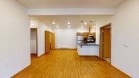 Located at 16609 East Desmont Court in Spokane Valley, WA, this single-floor unit offers a thoughtfully designed layout with a clean, modern aesthetic. The open-concept living area features warm hardwood-style flooring, recessed lighting, and a private entry door with windows that invite natural light. The space flows seamlessly into the kitchen, which is well-appointed with stainless steel appliances including a refrigerator and range, warm wood cabinetry, dark countertops, a tiled backsplash, and a peninsula with pendant lighting — ideal for both cooking and casual dining. A closet off the living area provides additional storage. Two carpeted bedrooms offer a comfortable retreat, each with a window fitted with blinds for natural light and privacy, and baseboard heating. The primary bedroom includes a built-in closet and an electrical panel. Two full bathrooms serve the unit, each featuring a tub/shower combo, a vanity with wood cabinetry, white countertops, and hardwood-style flooring. The overall design is cohesive, with warm wood tones from the doors, trim, and cabinetry complementing the crisp white walls throughout, creating a clean and inviting living environment.
