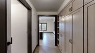 Located in Portland's NW Irving Street corridor, this single-floor unit showcases a thoughtfully designed interior with a consistent modern aesthetic. Polished concrete floors run throughout, providing a sleek, industrial character that ties the space together. Bold dark window trim and door frames create striking contrast against the crisp white walls, lending architectural definition to every room.

The kitchen is a standout feature, equipped with stainless steel appliances including a gas range, dishwasher, and full-size refrigerator. Two-tone cabinetry pairs taupe upper cabinets with dark lower units, complemented by a white subway tile backsplash and quartz countertops. A central island with pendant lighting adds both function and style. A sliding barn door accents the kitchen area, adding a contemporary touch.

Multiple rooms benefit from large wood-framed windows that frame views of mature trees and the surrounding neighborhood, filling the space with natural light. One room opens directly onto a private balcony through French doors. Built-in cabinetry and shelving provide ample storage throughout. The bathroom includes a fully tiled walk-in shower with chrome fixtures, while a second bathroom offers accessible features. An in-unit washer and dryer area is also present, completing this well-equipped and design-forward Portland residence.