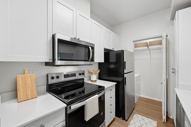 Cocina renovada del Paquete I con electrodomésticos de acero inoxidable modernos, gabinetes blancos, encimeras de cuarzo blanco y pisos de superficie dura. - eaves Dublin
