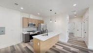 Located at 448 S Orange Ave in Newark, NJ, this thoughtfully designed 2-bedroom, 1-bathroom residence offers a clean, modern aesthetic throughout. Light-toned hardwood-style flooring runs continuously across the entire unit, creating a cohesive and bright interior.

The open-concept kitchen and living area serves as the heart of the home. The kitchen is outfitted with stainless steel appliances—including a gas range, over-the-range microwave, and refrigerator—complemented by two-tone cabinetry in natural wood and dark finishes, quartz countertops with a herringbone tile backsplash, and a center island with an undermount sink and stylish pendant lighting overhead.

The primary bedroom is generously sized and features a wide picture window offering serene views of mature trees and a green park setting, flooding the room with natural light. The second bedroom also benefits from natural light through its own window with leafy outdoor views.

The bathroom is elegantly appointed with large-format marble-look tile surrounding the soaking tub and shower, a white floating vanity, a rounded rectangular mirror, and matte black fixtures and lighting that lend a contemporary contrast.

Recessed lighting throughout and neutral white walls complete the clean, modern feel of this well-appointed Newark residence.