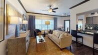 Located at 13333 West Rd in Houston, Texas, this thoughtfully designed single-floor residence blends modern style with functional living. The entryway welcomes you with rich hardwood-style flooring, crisp white walls, and striking dark crown molding that carries throughout the home, creating a cohesive and polished aesthetic.

The living room is an inviting, generously sized space bathed in natural light from large windows dressed with floor-length drapes. A ceiling fan adds comfort, while the warm tones of the area rug and neutral furnishings contribute to the room's relaxed yet refined atmosphere.

The galley-style kitchen is well-equipped, featuring white cabinetry, dark granite countertops, black subway tile backsplash, and black appliances. Crown molding and track lighting complete the sleek, contemporary look.

The bedrooms are spacious and serene, each carpeted for comfort and fitted with ceiling fans and large windows. The primary bedroom offers direct access to a private exterior door, mirrored sliding closets, and ample room to unwind. A second bedroom mirrors this comfortable design.

The bathroom is clean and functional, offering a dual-sink vanity with dark granite counters, wood-style flooring, a soaking tub, and a large mirror — delivering a spa-like finishing touch to this well-rounded Houston residence.