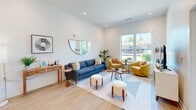 Located at 2708 Old Lebanon Pike in Nashville, TN, this one-bedroom, one-bathroom unit offers a thoughtfully designed open-concept layout with modern finishes throughout. Light wood-tone flooring extends across the main living areas, complementing the crisp white walls and recessed lighting that keep the space feeling bright and airy.

The living room is generously proportioned, featuring tall ceilings and large windows that flood the area with natural light and provide views of the surrounding greenery. The kitchen is a standout, showcasing white shaker cabinetry with gold-tone hardware, a stainless steel refrigerator and range, and a striking blue island with a white quartz countertop that doubles as a dining and prep space.

The bedroom is a comfortable retreat, highlighted by floor-to-ceiling corner windows that frame lush outdoor views and fill the room with natural light. Soft carpet flooring adds warmth underfoot. Adjacent to the bedroom is a closet providing dedicated storage, along with a well-appointed full bathroom featuring a spacious, accessible layout with a vanity, vinyl plank flooring, and accessibility grab bars. The unit's clean, contemporary design and efficient use of space make it a practical and stylish home in Nashville.