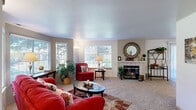 This single-floor, 2-bedroom, 1-bathroom home offers a thoughtfully organized layout that maximizes comfort and functionality. The inviting living room serves as the heart of the space, featuring a classic fireplace with a white surround, textured ceilings, plush carpeting, and a bank of windows that floods the room with natural light and garden views. The adjacent dining room connects seamlessly to both the living area and kitchen, and is equipped with a ceiling fan and sliding glass doors that open to the outdoors, enhancing the sense of space. A convenient pass-through window connects the dining room to the kitchen, which features light wood cabinetry, tile flooring, recessed lighting, and ample counter space. The primary bedroom is a comfortable retreat, offering a window with outdoor views, plush carpet, and generous proportions. The second bedroom features a sliding closet and cozy carpeting, making it well-suited as a guest room, nursery, or home office. The full bathroom includes a vanity with light wood cabinetry, tile flooring, and a shower-tub combination. A hallway connects the private areas of the home, completing this efficiently designed and move-in-ready floor plan.
