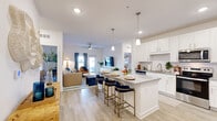 This single-story, 2-bedroom, 2-bathroom residence is thoughtfully designed to maximize functionality and comfort. The open-concept layout seamlessly connects the kitchen, dining area, and living room, creating a bright and cohesive communal space. Light wood-style flooring flows throughout the main living areas, enhancing the airy feel.

The kitchen is a standout feature, equipped with white shaker cabinetry, granite countertops, a subway tile backsplash, and a full suite of stainless steel appliances including a range, microwave, and dishwasher. A central island with seating provides an ideal spot for casual dining or entertaining.

The living room is bathed in natural light from large windows and a glass door that opens to the exterior, offering outdoor views. Ceiling fans are present in key rooms for added comfort.

The primary bedroom is a spacious retreat featuring plush carpet, a ceiling fan, and generous natural light. Both bedrooms include dedicated closets with built-in shelving. The two bathrooms are clean and functional, with one featuring a shower-tub combination. A dedicated in-unit laundry room with a full-size washer and dryer adds exceptional convenience, completing this well-appointed and practical home.