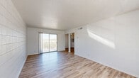 Located at 5300 Carousel Dr in El Paso, TX, this 2-bedroom, 1-bathroom unit offers a thoughtfully arranged single-floor layout. The bright living room features light wood-style flooring, a textured ceiling, and a sliding glass door that opens to a private balcony with outdoor views. Distinctive large-format white tile accent walls appear throughout multiple rooms, giving the space a consistent, clean aesthetic. The combined dining and kitchen area is well-equipped with white cabinetry, marble-style countertops, a stainless steel sink, and white appliances including an electric range and refrigerator — all set against a fully tiled backsplash and matching flooring. The primary bedroom is a comfortable size, carpeted for warmth, and includes a ceiling fan with light fixture and a window for natural light. The second bedroom also features carpet, a white tile accent wall, and a window. The shared bathroom is finished with elegant marble-style tile surrounding a full soaking tub and shower combination with chrome fixtures. A hallway connects the bedrooms to the main living areas, and a dedicated closet provides additional storage. The overall palette of whites and neutrals creates a clean, bright atmosphere throughout.
