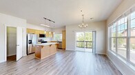 Located at 515 Aurora in Bend, Oregon, this two-story, 4-bedroom, 2-bathroom home offers a well-designed layout across two floors. The main level features an open-concept kitchen and living area bathed in natural light. The kitchen is equipped with warm wood cabinetry, stainless steel appliances, a center island with a white countertop, and pendant lighting overhead. The adjoining living room boasts light wood-style flooring, a chandelier, multiple windows, and sliding glass doors that open to a private balcony with outdoor views. A second living or flex space on the upper level features vaulted ceilings and a stone-surround gas fireplace, adding warmth and character. The primary bedroom includes vaulted ceilings, hardwood-style flooring, and a walk-in closet. The additional bedrooms are bright and well-proportioned with ample closet space. Both bathrooms feature warm wood vanities with white countertops and tile flooring. A dedicated laundry room with full-size washer and dryer hookups adds everyday convenience. Light, neutral tones and consistent flooring throughout create a cohesive and inviting atmosphere across the entire home.