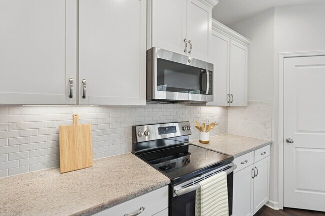 Paquete de actualización de cocina con gabinetes blancos, placa para salpicaduras de azulejos de diseño, encimeras de granito y electrodomésticos de acero inoxidable. - Avalon Townhome Collection Brier Creek