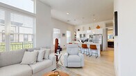 Located at 25 Whistler Ct in Saratoga Springs, NY, this well-appointed single-floor home offers two bedrooms and two bathrooms within a thoughtfully designed layout. The open-concept living room is a standout, boasting soaring ceilings, oversized windows that flood the space with natural light, a sleek fireplace, ceiling fan, and generous room for comfortable seating. The kitchen is modern and functional, featuring a large central island with pendant lighting, white cabinetry, a white subway tile backsplash, light hardwood flooring, and stainless steel appliances — all complemented by bright natural light from multiple windows. The primary bedroom is spacious, with plush carpet, a ceiling fan, and ample room to relax, while the second bedroom offers a clean, comfortable layout with fitted closets. Both bathrooms are finished with a consistent design aesthetic, showcasing stylish black penny tile flooring contrasted against crisp white walls. One bathroom includes a glass-enclosed walk-in shower, while the other features a shower-tub combination. Throughout the home, a neutral color palette and modern finishes create a bright, cohesive ambiance that is both welcoming and refined.