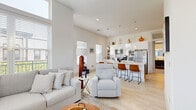 Located at 25 Whistler Ct in Saratoga Springs, NY, this well-appointed single-floor home offers two bedrooms and two bathrooms within a thoughtfully designed layout. The open-concept living room is a standout, boasting soaring ceilings, oversized windows that flood the space with natural light, a sleek fireplace, ceiling fan, and generous room for comfortable seating. The kitchen is modern and functional, featuring a large central island with pendant lighting, white cabinetry, a white subway tile backsplash, light hardwood flooring, and stainless steel appliances — all complemented by bright natural light from multiple windows. The primary bedroom is spacious, with plush carpet, a ceiling fan, and ample room to relax, while the second bedroom offers a clean, comfortable layout with fitted closets. Both bathrooms are finished with a consistent design aesthetic, showcasing stylish black penny tile flooring contrasted against crisp white walls. One bathroom includes a glass-enclosed walk-in shower, while the other features a shower-tub combination. Throughout the home, a neutral color palette and modern finishes create a bright, cohesive ambiance that is both welcoming and refined.