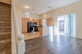 This two-story home offers a thoughtfully designed layout with a bright, open feel throughout. The main level centers around a generous living area with soaring ceilings and sliding glass door access to an outdoor space, allowing natural light to pour in. Rich hardwood-style flooring flows through the living and dining areas, complementing the warm, neutral color palette on the walls.

The kitchen is well-appointed with light wood cabinetry, granite-style countertops, a double-basin sink, and black appliances including a gas range, refrigerator, microwave, and dishwasher. Tile flooring and a bright window complete the functional workspace.

Upstairs, the bedrooms feature plush carpeting and multiple windows fitted with blinds that invite natural light while maintaining privacy. The primary bathroom is a standout, offering a dual-sink vanity with granite countertops, wood-style flooring, a glass-enclosed shower, and a separate soaking tub. Additional bathrooms maintain a consistent design aesthetic with granite counters and wood-style flooring.

A dedicated laundry area includes side-by-side washer and dryer hookups alongside extensive built-in cabinetry, providing exceptional storage capacity. Throughout the home, recessed lighting, clean white trim, and a cohesive neutral palette create a bright, move-in-ready environment.