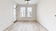 Located at 2314 Berryhill Rd in Charlotte, NC, this well-designed 2-bedroom, 2-bathroom single-floor home offers a clean, modern aesthetic throughout. Light wood-look luxury vinyl plank flooring runs seamlessly across every room, complementing the crisp white walls and bright, airy atmosphere. The standout kitchen features a bold two-tone design with deep navy lower cabinets, white upper cabinets, and a herringbone tile backsplash. Stainless steel appliances, a deep single-basin sink with a matte black faucet, and a large peninsula with white countertops complete the space, making it as functional as it is visually striking. Recessed lighting illuminates the open connection between the kitchen and living areas, which also benefit from natural light streaming through multiple windows. Both bedrooms are well-proportioned and bright, each fitted with ceiling fans and windows that bring in natural light and exterior views. The bathrooms are finished with clean, modern fixtures — one features a tiled tub-shower combo with white subway tile, a white vanity, and matte black hardware, while the second bathroom includes accessible support features. A hallway and closet provide practical storage and circulation throughout the home.