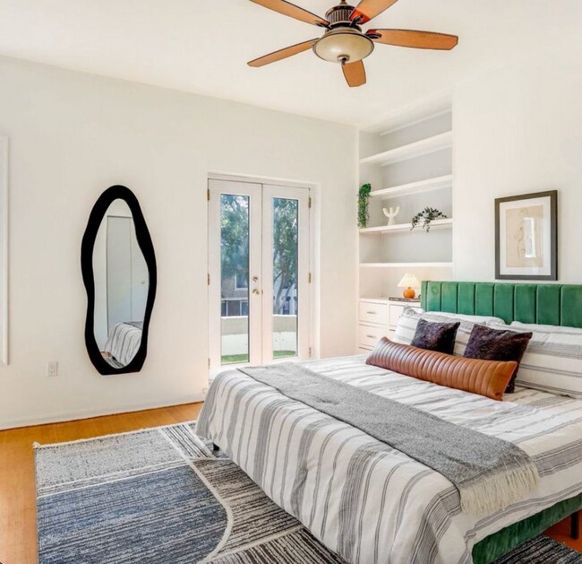 Primary bedroom with build in bookshelves two closets and a balcony - 1630 6th St NW