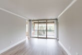 Located at 1300 Sanderson Drive in Sterling, Virginia, this 4-bedroom, 2-bathroom unit offers a well-designed single-floor layout with a clean, modern aesthetic throughout. Light wood-tone flooring extends across the entire space, complemented by neutral warm-gray walls, crisp white crown molding, and bright white baseboards that give each room a polished, cohesive feel.

The living area is a standout, featuring floor-to-ceiling sliding glass doors that flood the space with natural light and open directly onto a private balcony with outdoor views — an ideal spot for relaxing or entertaining. The galley-style kitchen is thoughtfully appointed with gray shaker cabinets, matte black hardware, white quartz countertops, a stainless steel sink, and a full suite of black appliances including a gas range, microwave, and refrigerator.

The four bedrooms are generously proportioned, with the spacious primary bedroom offering a closet and natural light from a window with outdoor views. The remaining bedrooms each feature windows that bring in natural light. Two full bathrooms serve the unit, both featuring gray shaker vanities with white countertops, matte black fixtures, and light wood-tone flooring. Additional storage is provided by dedicated closets throughout. The overall ambiance is bright, clean, and move-in ready.