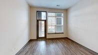 This contemporary 790 square foot apartment in Herndon, VA offers a thoughtfully designed living space. The open-concept layout seamlessly integrates the kitchen, living, and dining areas, creating a spacious feel. The kitchen is a standout feature, boasting a sleek design with a combination of white and wood-tone cabinetry, subway tile backsplash, and high-end stainless steel appliances. A central island provides additional counter space and casual dining options.

The living area is bathed in natural light, thanks to large windows with horizontal blinds. These windows not only brighten the space but also offer views of the surrounding area. The bedroom, measuring 140 square feet, continues the apartment's modern aesthetic with neutral walls and hardwood flooring. A well-organized closet system provides ample storage.

The bathroom features a clean, contemporary design with a spacious vanity, large mirror, and a shower/tub combination. Throughout the apartment, the hardwood flooring adds warmth and elegance, while recessed lighting enhances the modern ambiance. The efficient layout maximizes the use of space, making this one-bedroom apartment feel larger than its 790 square feet would suggest.