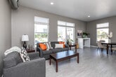 Located in the heart of downtown Des Moines at 550 Watson Powell Jr Way, this well-appointed one-bedroom, one-bathroom unit offers a thoughtfully designed open-concept layout. The combined kitchen and living area serves as the centerpiece of the home, featuring a sleek, modern kitchen with white cabinetry, stainless steel appliances, a bold orange tile backsplash, and light wood-style flooring. Large windows flood the kitchen and dining nook with natural light while framing views of the surrounding urban skyline and streetscape.

The living area is generously proportioned, with exposed industrial-style ductwork adding an urban loft character. Additional windows in the living space continue to bring in natural light and city views, including a notable view of a historic church across the street.

The spacious primary bedroom features plush blue carpeting and direct access to a dedicated walk-in closet equipped with wire shelving and an in-unit washer. The full bathroom includes a tub/shower combination with clean finishes. A distinctive orange entry door adds a pop of personality to the unit's corridor entrance. Throughout, the neutral warm-gray wall palette and consistent design language create a cohesive, modern urban living environment.