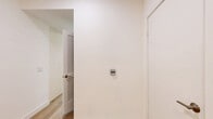 Located at 2968 W 7th St in Los Angeles, this well-appointed one-bedroom, one-bathroom unit offers a clean, modern aesthetic throughout its thoughtfully designed layout. Light-toned wide-plank hardwood flooring runs continuously across the living spaces, creating a bright and cohesive feel.

The open-concept kitchen and living area serves as the heart of the unit. The kitchen is outfitted with high-gloss cream cabinetry, stainless steel appliances including a range, microwave, and refrigerator, and a glass tile backsplash with under-cabinet lighting. A peninsula with pendant lighting above connects the kitchen to the living area, making the space ideal for both everyday living and entertaining.

The bedroom is a comfortably sized retreat featuring a built-in sliding-door closet and large windows that allow natural light to fill the room and provide views of the surrounding neighborhood. The crisp white walls complement the warm wood flooring throughout.

The bathroom features large-format tile in the tub and shower surround, a clean vanity with ample drawer storage, and a well-lit mirror. The overall design of the unit emphasizes a minimalist, contemporary style with neutral tones and modern fixtures, creating a polished and functional living environment in the heart of Los Angeles.