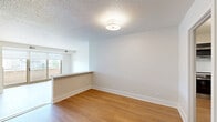 Located at 2201 Wisconsin Ave NW in Washington, DC's desirable Georgetown neighborhood, this two-bedroom, two-bathroom residence offers a well-designed single-level layout with a comfortable and functional floor plan. Light-toned hardwood-style flooring runs throughout the living areas and bedrooms, lending warmth and visual continuity to the space.

The open living area is bright and airy, featuring sliding glass doors that lead to a private balcony, allowing natural light to pour in. The kitchen is a standout feature, outfitted with bold navy cabinetry, white quartz countertops, stainless steel appliances — including a range, microwave, and refrigerator — and open shelving, striking a balance between style and practicality. An in-unit stacked washer and dryer is conveniently housed within the kitchen area alongside additional cabinetry for storage.

Both bedrooms are generously proportioned with hardwood-style flooring, neutral walls, and ample closet space. The primary bedroom is spacious and includes a large double-door closet. The two bathrooms are clean and modern, each featuring a full tub-shower combination with chrome fixtures and light grey tile flooring. One bathroom benefits from a window with a view of greenery, adding a refreshing touch. A connecting hallway ties the layout together seamlessly.