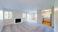 This thoughtfully designed 2-bedroom, 2-bathroom residence offers a comfortable and functional single-floor layout. The open-concept living room is a welcoming centerpiece, featuring a classic white-surround fireplace, plush carpeting, and a sliding glass door that opens onto a private balcony with outdoor views — allowing abundant natural light to fill the space. The adjacent kitchen is efficiently arranged with light gray shaker-style cabinetry, ample counter space, stainless steel appliances including a refrigerator, range, and dishwasher, and warm hardwood flooring that contrasts nicely with the carpeted living areas. Both bedrooms are comfortably sized with soft carpet, large windows that invite natural light, baseboard heating, and closet storage. The primary bedroom offers a quiet retreat with its own dedicated space. The two bathrooms are finished cleanly in neutral tones — one features a single vanity with a white cabinet and framed mirror, while the other includes a full bathtub and shower combination with grab bars. Throughout the residence, the neutral color palette, clean lines, and consistent finishes create a bright, cohesive, and move-in-ready living environment.