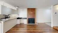 Located at 659 S Cloverdale Ave in the heart of Los Angeles, CA, this single-floor residence offers a well-designed layout with a blend of functional and stylish features throughout. Rich hardwood flooring flows across the main living areas, complemented by a textured ceiling that adds character to the space.

The living area serves as the focal point of the unit, highlighted by a striking floor-to-ceiling wood-paneled fireplace framed in warm tones, creating a cozy and inviting atmosphere. A built-in desk with white cabinetry and a dark countertop offers a dedicated workspace, while mosaic tile backsplash detailing adds a decorative touch nearby. A unique multi-panel frosted glass sliding door separates living spaces, adding a modern, artful element to the interior.

The kitchen is equipped with stainless steel appliances, including a refrigerator, electric range, and over-the-range microwave. Granite countertops and white cabinetry provide ample storage and a clean aesthetic, with tile flooring and a window allowing natural light to brighten the space.

The bathroom features a granite-topped vanity with an undermount sink, a combination tub and shower with white subway tile surround, track lighting, and a grab bar for added accessibility.

A sliding glass door opens to a private balcony, offering outdoor views and natural light that brighten the living area, making the space feel open and connected to the surrounding neighborhood.