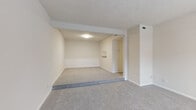 This single-floor residence offers a clean, neutral aesthetic with a cohesive design throughout. The open living area is finished with plush gray carpeting and features a textured ceiling, a subtle split-level layout, and a dedicated HVAC vent for climate control. A secondary living or dining area flows naturally from the main space, enhanced by a front entry door and window with blinds that allow natural light to fill the room.

The kitchen is a functional highlight, outfitted with gray shaker-style cabinetry, granite-inspired countertops, a stainless steel range, a stainless sink, and light wood-look tile flooring. Ample upper and lower cabinet storage provides excellent utility, and a pantry closet adds to the kitchen's practicality.

The bedrooms are carpeted and bright, each with windows fitted with blinds that offer both natural light and privacy. The bathrooms are finished with matching granite-style vanity countertops, gray cabinetry, and light tile flooring. One bathroom includes a soaking tub, while another features a toilet, single vanity, and a grab bar. Hallway access connects the sleeping quarters to the bathrooms seamlessly.

Overall, the space presents a well-maintained, move-in ready layout with consistent finishes, a light color palette, and practical design elements throughout.