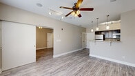 Located at 508 N College Ave in Bloomington, Indiana, this one-bedroom, one-bathroom unit offers a well-planned single-floor layout designed for comfortable everyday living. Consistent hardwood-style flooring flows throughout the entire space, tying each room together cohesively.

The open-concept living area is bright and welcoming, featuring a ceiling fan with light fixture, track lighting, and large windows fitted with blinds that invite natural light while maintaining privacy. A sliding barn-style door connects the living room to the generously sized bedroom, which also includes its own ceiling fan and a window with outdoor views.

The kitchen is efficiently designed with dark espresso cabinetry, granite-style countertops, and a full suite of stainless steel appliances including a refrigerator, range, and microwave. A peninsula counter with pendant lighting above provides additional prep space and casual seating, opening directly to the living area.

The bathroom features a dark-toned vanity with a white countertop, a large mirror, and overhead lighting, maintaining the unit's clean, modern aesthetic. Additional storage is provided by a dedicated closet. The unit's warm neutral wall tones and modern finishes throughout create a cohesive and functional living environment.