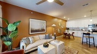 This thoughtfully designed single-floor residence in McCordsville, Indiana offers a cohesive open-concept layout that seamlessly connects the living room, dining area, and kitchen. The living space is anchored by warm terracotta accent walls, wood-look flooring, a ceiling fan, and recessed lighting that together create a welcoming, contemporary ambiance. Natural light filters in through multiple windows dressed with blinds and floor-length curtains. The kitchen is a standout feature, showcasing white shaker cabinetry, granite countertops, a subway tile backsplash, stainless steel appliances, and a peninsula island with pendant lighting and bar seating — ideal for both everyday meals and casual entertaining. A separate dining area provides additional space for seated dining. The spacious primary bedroom features plush carpeting, a calming sage green accent wall, and a large window, with direct access to the full bathroom. The bathroom is well-appointed with a granite-topped double vanity and organized closet storage. Three closets throughout the home offer ample storage. A dedicated laundry room with full-size washer and dryer completes this efficiently planned home.