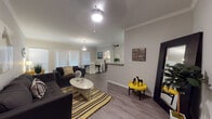 This single-floor residence offers a thoughtfully designed open-concept layout that seamlessly connects the living, dining, and kitchen areas. The living room is anchored by smooth hardwood-style flooring, crown molding, and neutral-toned walls that create a bright and welcoming atmosphere. Large windows with horizontal blinds allow generous natural light to fill the space, while a ceiling fan adds both style and function overhead.

The kitchen is well-equipped with stainless steel appliances, including a range, microwave, and dishwasher, complemented by crisp white cabinetry that extends to the upper walls for ample storage. Light granite-style countertops provide generous prep space, and the layout connects conveniently to the dining area via a half-wall pass-through.

The bedroom is a serene retreat featuring plush wall-to-wall carpeting, crown molding, and a ceiling light fixture. A wide window brings in natural light, and a spacious walk-in closet offers excellent storage capacity.

The bathroom is clean and functional, featuring a single vanity with light countertops, a tub-shower combination, and hardwood-style flooring that continues the cohesive aesthetic of the home. Throughout the space, consistent finishes, neutral tones, and modern fixtures contribute to a polished and comfortable living environment.