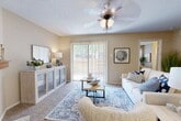 Located at 5207 Hollytree Dr in Tyler, TX, this single-story, 2-bedroom, 2-bathroom home offers a well-organized and comfortable layout. The combined living and dining area serves as the heart of the home, featuring a wood-burning fireplace, plush carpet, a textured ceiling, and a ceiling fan with light fixture. Large sliding glass doors flood the space with natural light and provide direct access to an outdoor patio, offering views of the surrounding greenery. The kitchen is functional and conveniently positioned adjacent to the living area. The primary bedroom is a generously sized retreat with its own ceiling fan, carpeted floors, and a walk-in closet complete with wire shelving for ample storage. The second bedroom is equally comfortable, also featuring a ceiling fan and soft carpet. Both bathrooms are finished with light, neutral tones, wood-style flooring, vanities with speckled countertops, and tub-shower combinations. A dedicated utility room and three total closets provide practical storage throughout. The home's warm, neutral color palette and consistent design elements create a cohesive and inviting ambiance from room to room.
